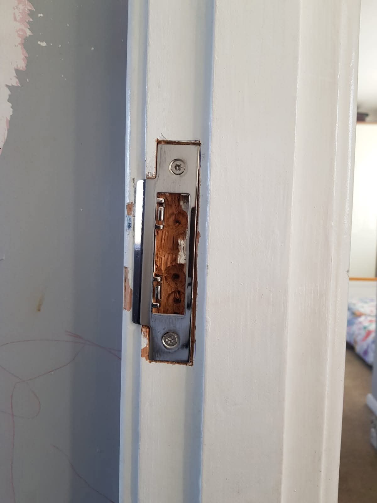 Door lock striker plate fitted into a frame
