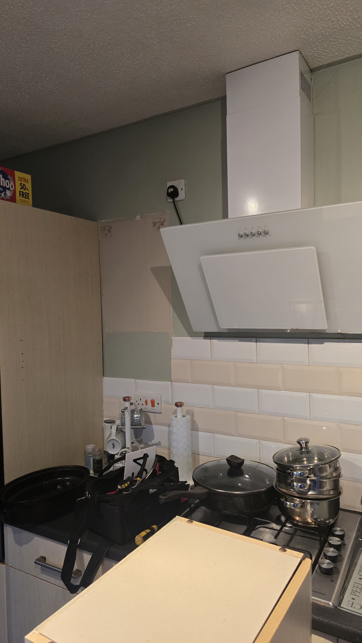 Cooker hood and extractor installed above a hob
